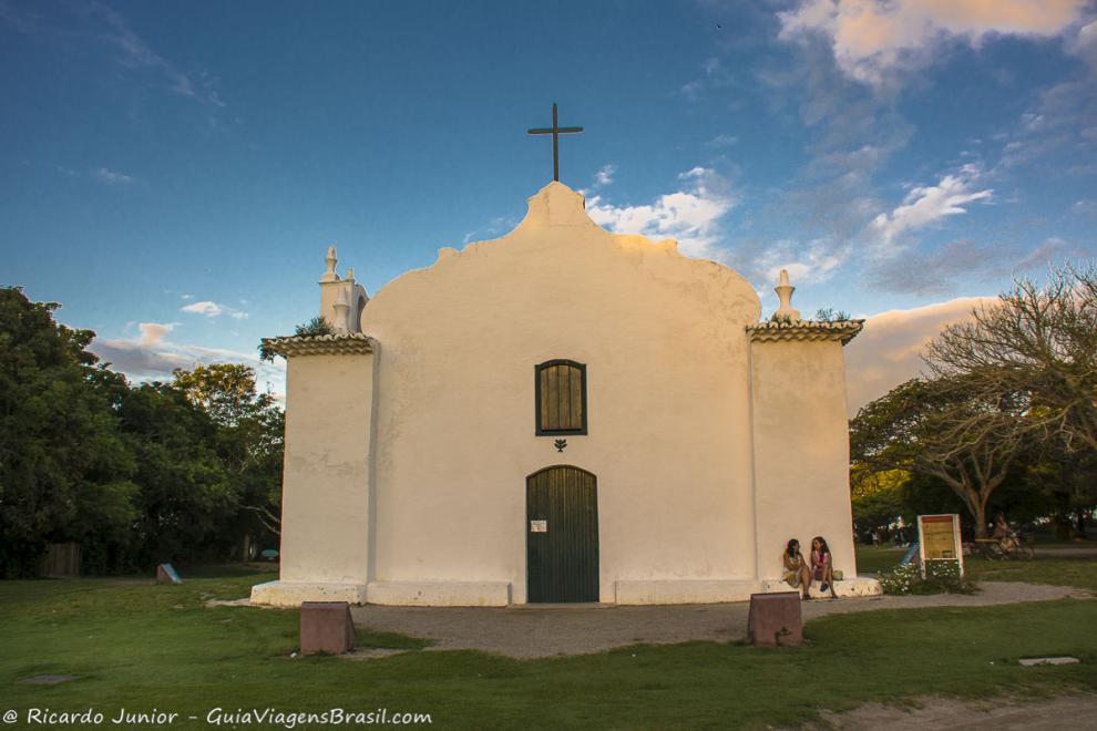 Imagem de duas amigas sentadas na frente da igreja conversando em Quadrado.